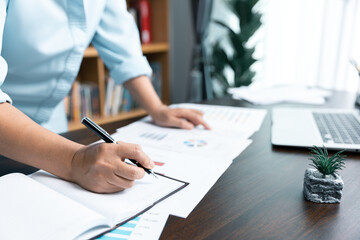 Businesswomen working to analyze, work together to discuss company financial statistics, brainstorm ideas, and graph documents on the table.