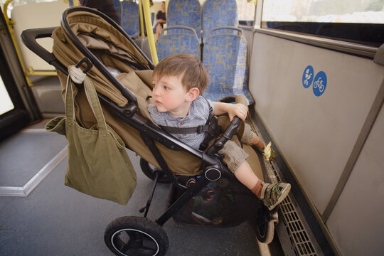 The baby is in a stroller on the bus, enjoying the mobility and transportation of public transit. Kid boy aged two years (two-year-old)