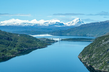 Naklejka na ściany i meble Scenic fjords in Norway with bridge and snow covered mountains