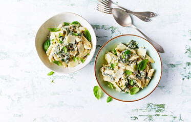 Penne pasta with creamy spinach sauce and parmesan. Top view