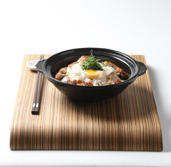 Hong Kong congee porridge rice with seafood unagi fish, mushroom, egg and vegetables in black hot clay pot on wood tray chopstick white background asian chef halal food restaurant banquet cafe menu