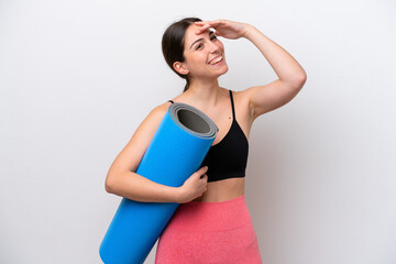 Young sport girl going to yoga classes while holding a mat isolated on white background smiling a lot