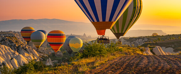Hot air balloons flying over the valley at Cappadocia, Turkey. - obrazy, fototapety, plakaty