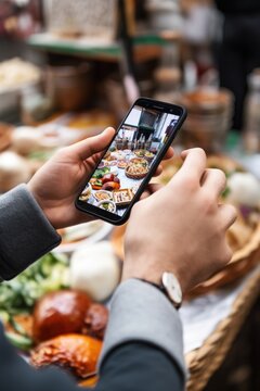 shot of a man taking pictures of food with his cellphone