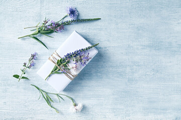 White gift box decorated with purple flowers. Top view. Copy sapce