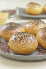 Donat tiramisu, sweet donuts with a variant of Tiramisu topping, served on a plate with a white background