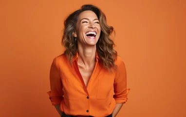 Fotobehang happy 40 years old businesswoman, who is smiling and laughing, wearing bright clothes. orange background, studio photos. created by generative AI technology. © hakule