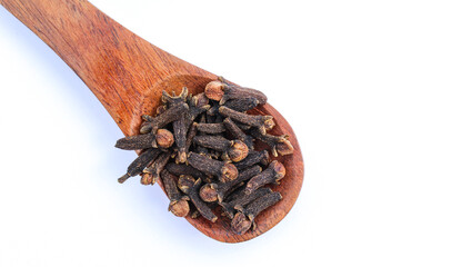 Dried Cloves in a wooden spoon on white background 