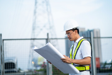 Engineer holding blueprints at construction site. Planning and working on the construction and...