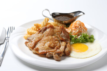 grilled golden bbq chicken chop pork cutlet beef steak with fried egg, French fries, coleslaw salad and black pepper sauce on brown leather white background western chef halal food restaurant menu