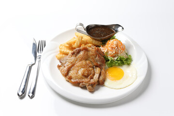 grilled golden bbq chicken chop pork cutlet beef steak with fried egg, French fries, coleslaw salad and black pepper sauce on brown leather white background western chef halal food restaurant menu