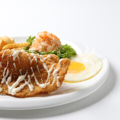 deep fried golden crispy fish fillet and chips with fried egg, French fries, coleslaw salad in tartar sauce on brown leather white background western chef halal food restaurant banquet menu cafe