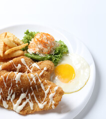 deep fried golden crispy fish fillet and chips with fried egg, French fries, coleslaw salad in tartar sauce on brown leather white background western chef halal food restaurant banquet menu cafe