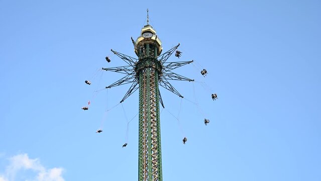 People are enjoying in the Amusement park with family members and rides during the summer evening.