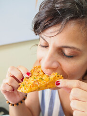 Caucasian tourist woman eating a Tortilla de Camarones (Spanish shrimp fritters). Typical dish from Cadiz, Andalusia, Spain