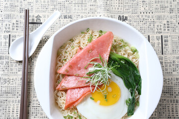 cook Japanese instant noodle mee soup with chicken ham, fried egg and vegetables on bowl chopstick on white vintage newspaper background asian chef halal food restaurant banquet menu