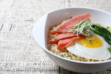 cook Japanese instant noodle mee soup with chicken ham, fried egg and vegetables on bowl chopstick on white vintage newspaper background asian chef halal food restaurant banquet menu
