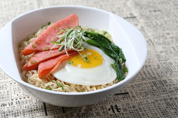 cook Japanese instant noodle mee soup with chicken ham, fried egg and vegetables on bowl chopstick on white vintage newspaper background asian chef halal food restaurant banquet menu