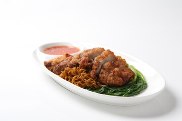 local wanton noodle mee in dark soy sauce with chicken chop cutlet, vegetables and chilli sauce in plate chopstick on white vintage newspaper background asian chef halal food restaurant banquet menu