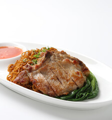 dry wanton noodle mee with grilled chicken pork cutlet and vegetable in dark soy and chilli sauce on plate chopstick on white vintage newspaper background asian chef halal food restaurant banquet menu