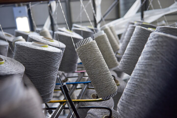 Raw spindles of industrial cotton in a weaving factory, hand weaving cotton for the fashion and textiles industry. Yarn weave traditional textile fabric manufacturing for clothing and fashion. - obrazy, fototapety, plakaty