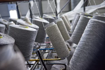 Fototapeten Raw spindles of industrial cotton in a weaving factory, hand weaving cotton for the fashion and textiles industry. Yarn weave traditional textile fabric manufacturing for clothing and fashion. © dannyburn