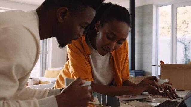 Closeup of a Black Couple Discussing Paint swatches while Sipping Tea