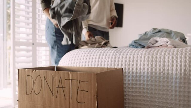 Black Couple Putting Clothes into a Donation Box