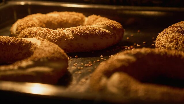 Homemade bagels with sesame baking in kitchen oven. Popular turkish food. Fresh simits. Organic food baking. Timelapse. Close-up in 4K, UHD