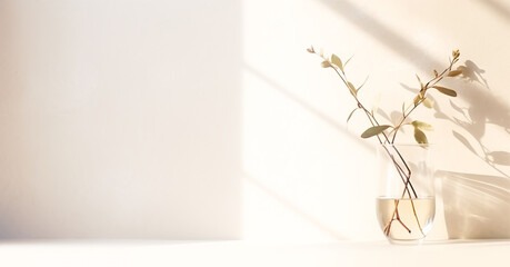 minimalistic composition with a twig standing in a vase against a white wall illuminated by the morning sun. Generative Ai.