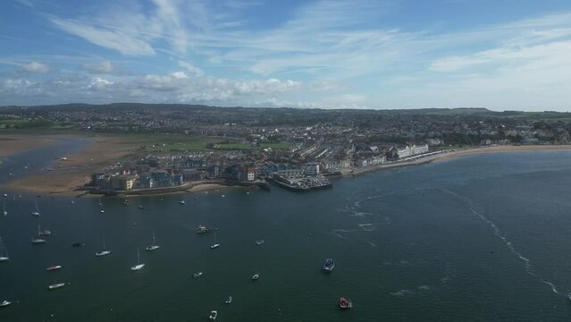 Exmouth, South Devon, England: DRONE VIEWS: The drone flies over the River Exe estuary & moored boats towards Exmouth showing the Pier Head (Exmouth Marina is behind it), the Esplanade and beach. 