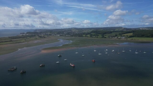 River Exe, South Devon, England: DRONE VIEWS: The drone flies over boats towards Shutterton Creek and the mainland. The River Exe is a popular UK holiday destination area (Clip 1).