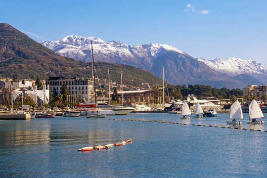 Beautiful winter Mediterranean landscape. Montenegro. View of Bay of Kotor, Tivat city and snow-capped Lovcen mountain on sunny day