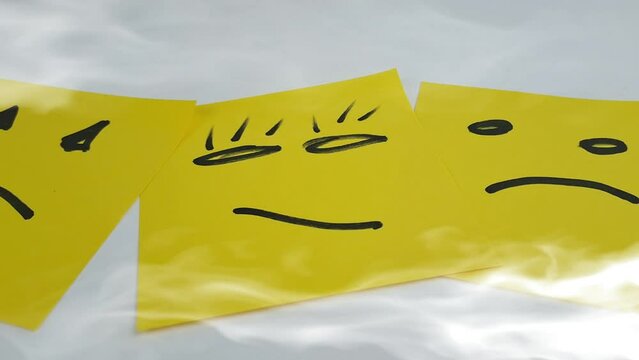 Sad smileys drawn on post-it notes, last smiley face. With smoke effect.