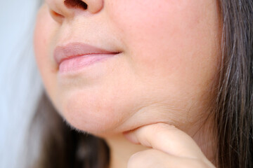 close-up of charismatic mature woman 50 years old looks carefully examines double chin, skin folds,...