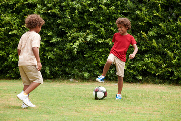 Kids enjoying playing soccer in backyard on sunny day