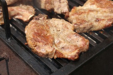 Pork chop on a steaming grill, well done