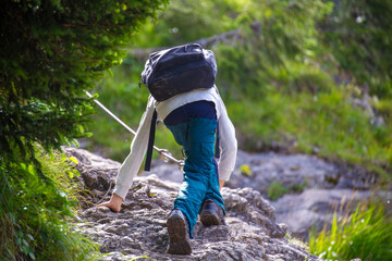 Wandern in den Allgäuer Alpen: Junge an einer mit Drahtseil gesicherten Passage beim Aufstieg von...