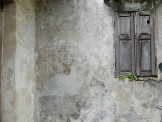 Old wooden window and rusty and grunge concrete wall surface.