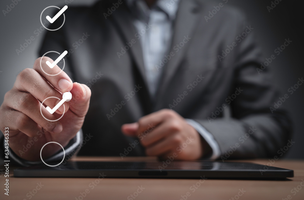 Poster Businessman using pen to tick correct sign mark in checkbox for quality document control checklist ,document approve and business approve project concept.