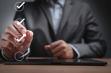 Businessman using pen to tick correct sign mark in checkbox for quality document control checklist...