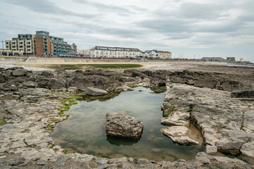 A view of Porthcawl, taken from the beach, with a rockpool in the foreground. 
