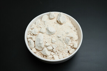 dry onion powder in a white plate on a black background