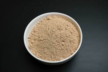 Ginger Root Powder on a white plate on a black background