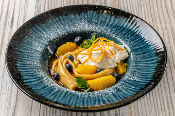 Pancakes with caramelized oranges and blueberries served in an ice cream restaurant