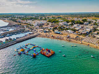 spiaggia di Campomarino di Maruggio con il mare turchese e il parco acquatico in estate  - Italy,...