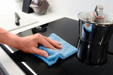 Fototapeta na wymiar Hand cleaning induction stove