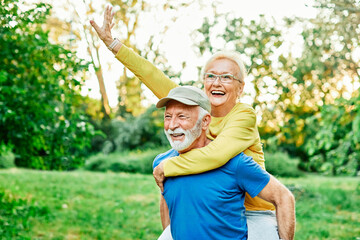 outdoor senior fitness woman man love active fun piggyback exercise healthy fit sport retirement...
