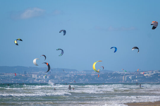 Kiteboarding kitesurfing kiteboarder kitesurfer kites on the Atlantic ocean beach at Fonte da Telha beach, Costa da Caparica, Portugal