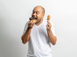 Asian man eating Sweet donut dessert. Hungry Young man holding chocolate donut unhealthy food. Food and dessert concept.